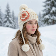 Children's winter cap with ear coverage and playful pom-pom