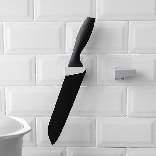 A sleek black punch-free wall hanging knife holder mounted on a kitchen wall, showcasing its modern design and space-saving functionality.