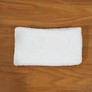 Person cleaning wooden furniture surface with microfiber cloth