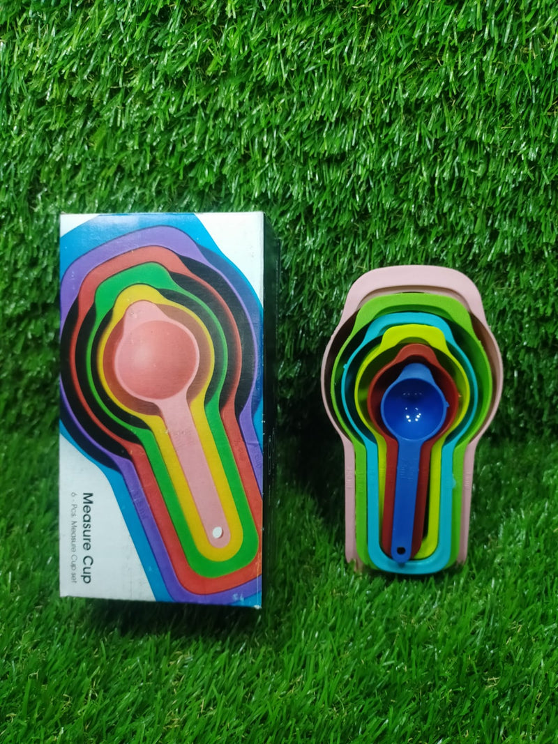 Detail shot of a pink plastic measuring spoon with easy-to-read measurement markings.