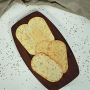 Hand holding a Maniarr's Jeera Slim Bite, emphasizing its convenient snack size.